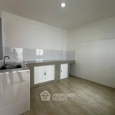 Spacious modern kitchen with sleek countertops and ample storage space.