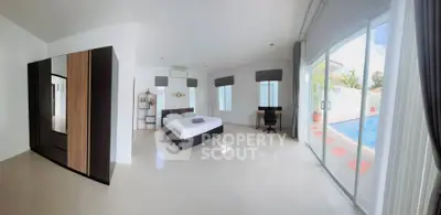 Spacious bedroom with pool view and modern furnishings