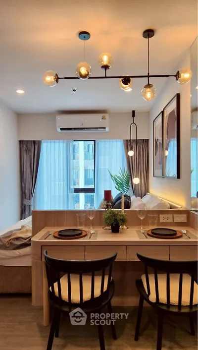 Modern dining area with stylish lighting and cozy seating in a contemporary apartment.