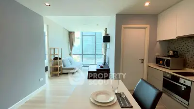 Modern open-plan living room and kitchen with sleek design and city view.