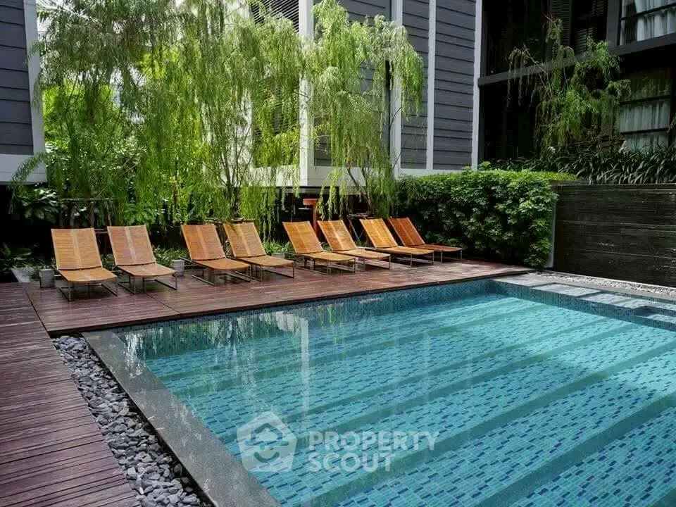 Luxurious outdoor pool area with modern design and lush greenery, perfect for relaxation and leisure.