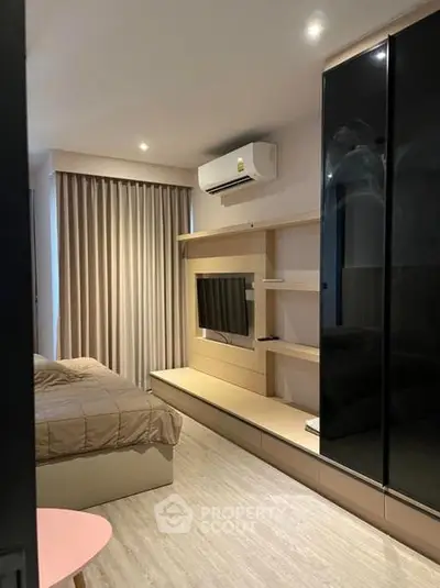 Modern bedroom with sleek design, featuring built-in TV and air conditioning.