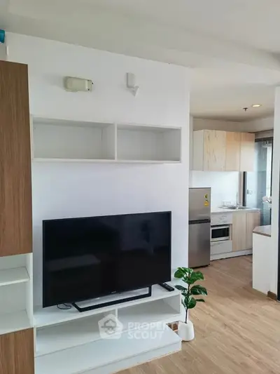 Modern living room with TV and open kitchen layout in stylish apartment