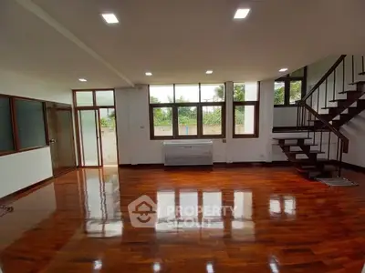 Spacious living room with wooden flooring and large windows