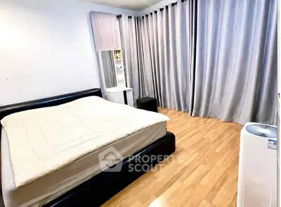 Spacious bedroom with elegant curtains and wooden flooring, featuring a comfortable bed and modern air purifier.
