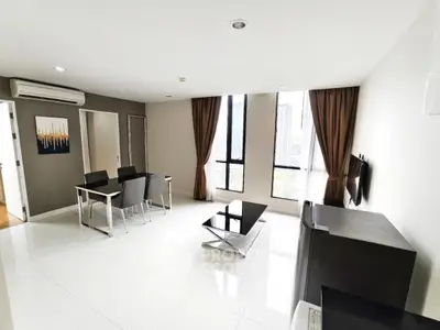 Modern living room with sleek furniture and large windows offering city views.