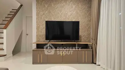 Modern living room with stylish TV stand and elegant staircase