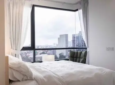 Modern bedroom with large window offering stunning city view