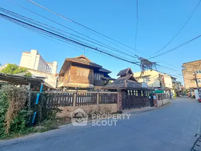 Charming traditional wooden house with rustic fence on a sunny street