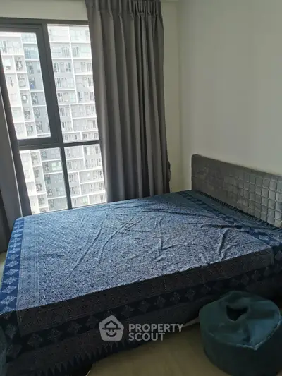 Cozy bedroom with large window and modern decor in urban apartment