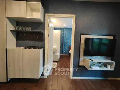Modern apartment interior with stylish wall-mounted TV and open shelving.