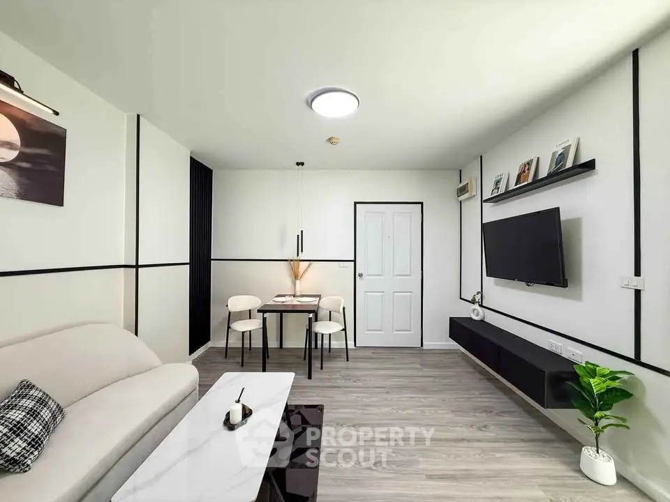 Modern living room with sleek decor, wall-mounted TV, and cozy dining area.