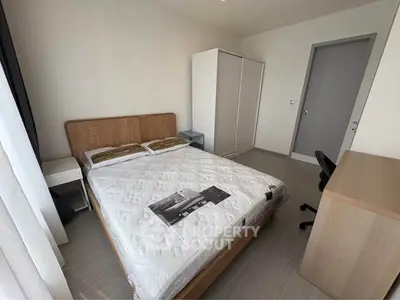 Modern bedroom with minimalist design featuring a cozy bed, wardrobe, and study desk.