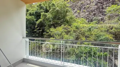 Charming balcony with lush green view, perfect for nature lovers seeking tranquility.