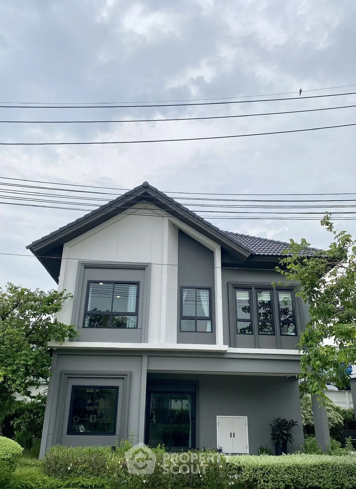 Modern two-story house with sleek design and lush greenery