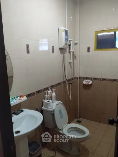 Cozy bathroom with shower and essential amenities in a compact layout.