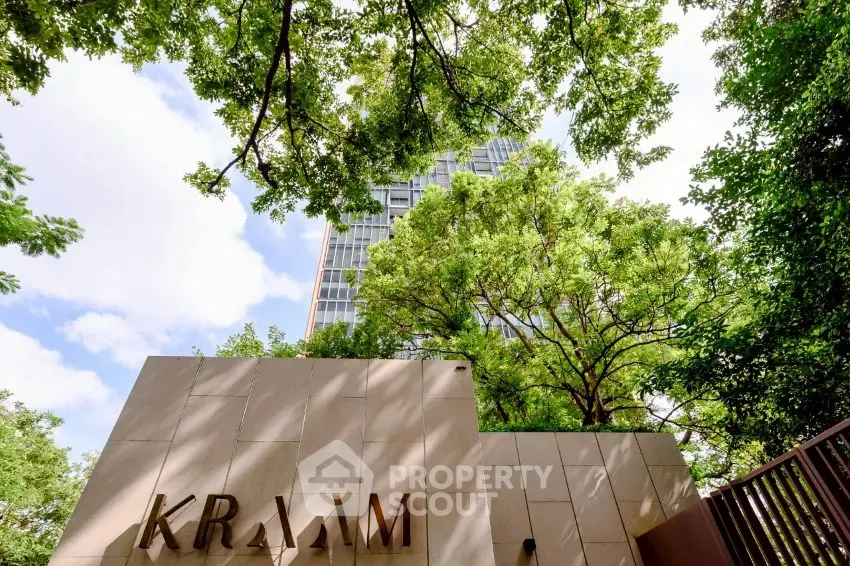 Modern building exterior with lush greenery and elegant architecture.