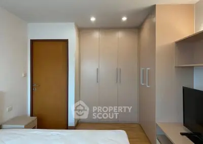 Modern bedroom with built-in wardrobe and sleek wooden finishes