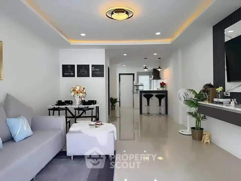 Modern open-plan living room with stylish decor and sleek kitchen area