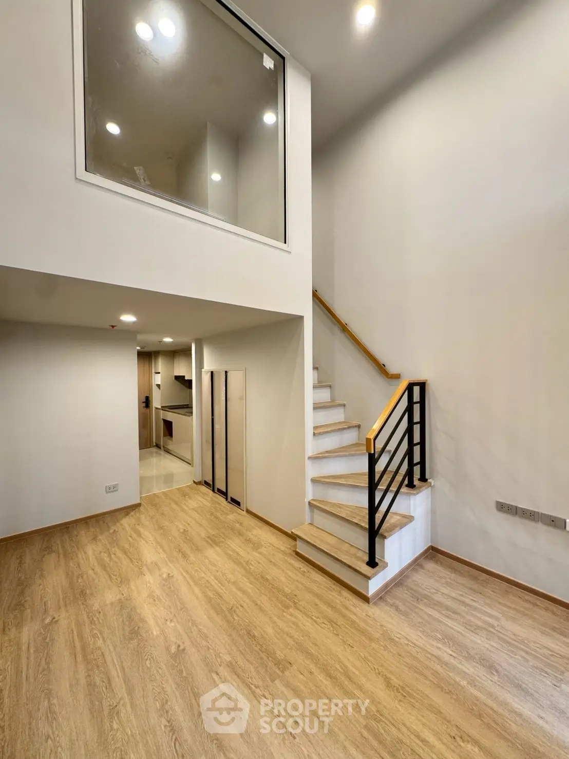 Modern duplex interior with wooden flooring and sleek staircase