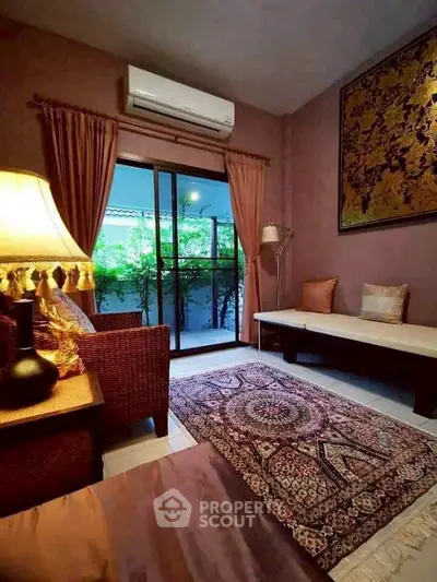 Charming living room with elegant decor and garden view through sliding glass doors.