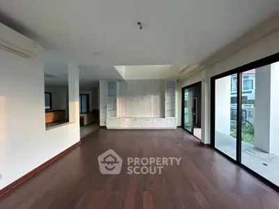 Spacious modern living room with hardwood floors and large windows