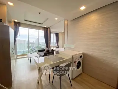 Modern open-plan living room with city view and in-unit washing machine.