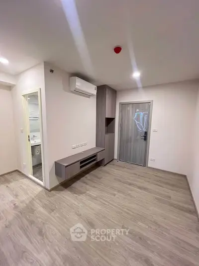 Modern minimalist living room with wooden flooring and built-in storage