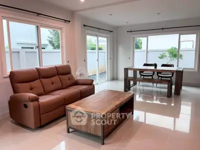 Spacious living room with modern furniture and large windows offering natural light.