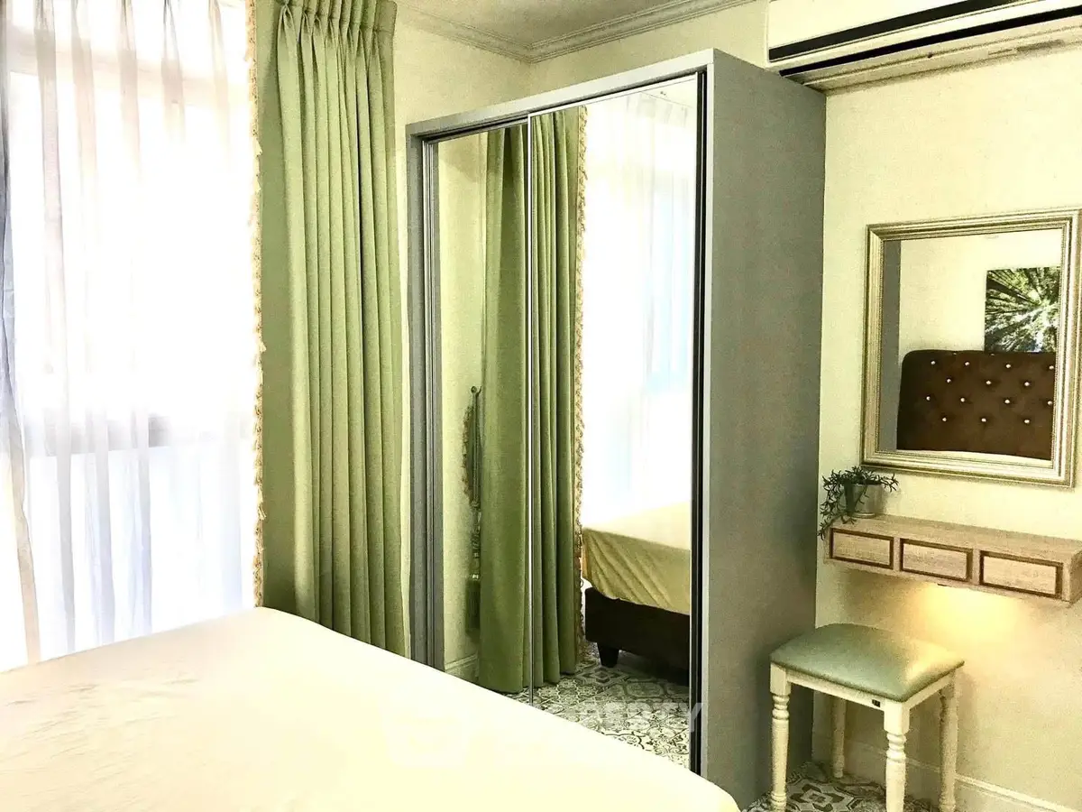 Charming bedroom with mirrored wardrobe and elegant green curtains
