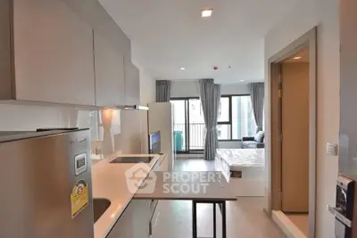 Modern open-plan kitchen with sleek design and natural light in urban apartment.