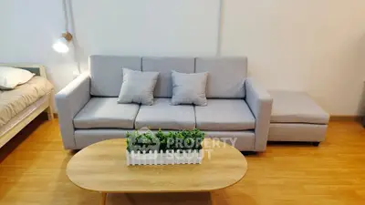 Modern living room with stylish gray sofa and wooden coffee table in cozy apartment.