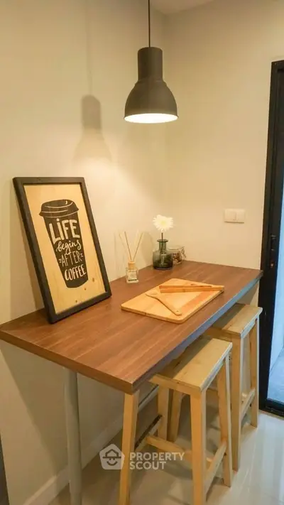 Cozy kitchen nook with wooden table and stools, perfect for morning coffee.