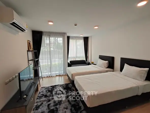 Modern bedroom with twin beds, large window, and sleek decor