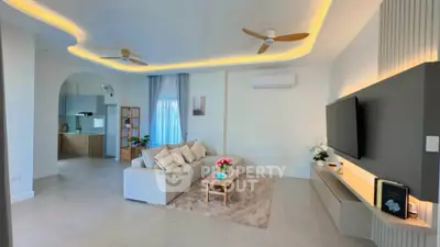 Spacious modern living room with elegant ceiling lights and open kitchen layout
