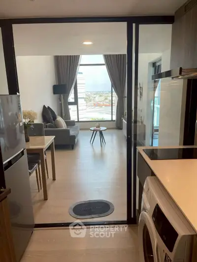 Modern apartment with open kitchen and spacious living room featuring city view.