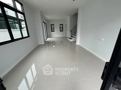 Spacious modern living room with glossy tiled floors and large windows