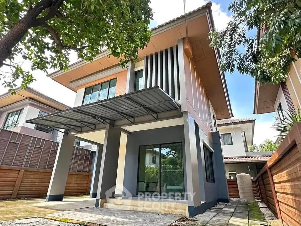 Modern two-story house with sleek design and spacious outdoor area in a serene neighborhood.