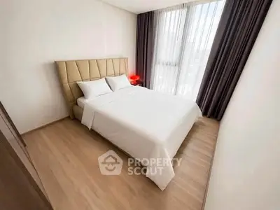 Modern bedroom with elegant decor and large window for natural light.
