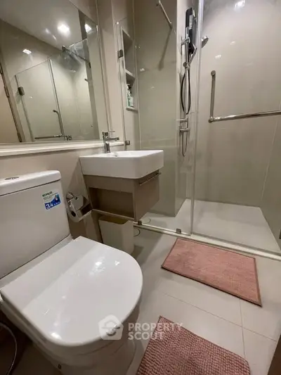 Modern bathroom with glass shower and sleek fixtures in a contemporary apartment.