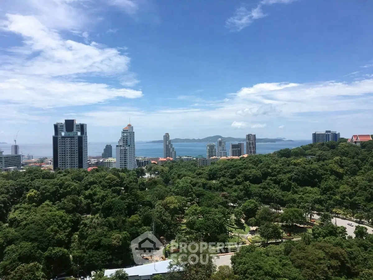 Stunning cityscape view with lush greenery and ocean backdrop, ideal for urban living.