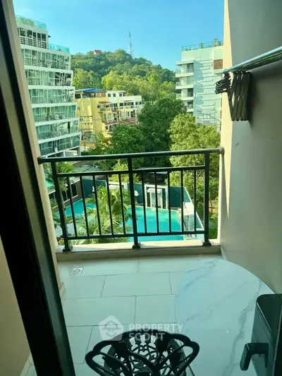 Charming balcony view overlooking lush greenery and modern buildings, perfect for relaxation.