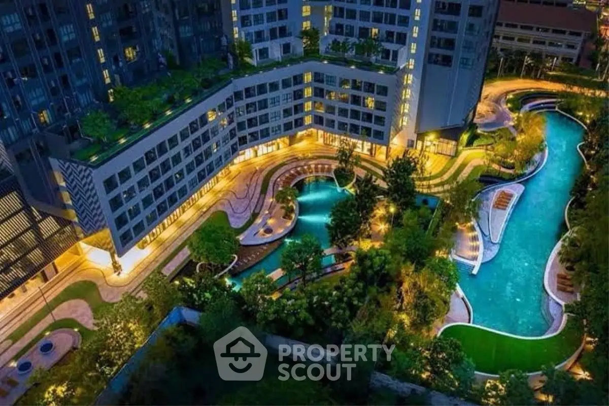 Luxurious apartment complex with stunning night-lit pool and lush gardens.
