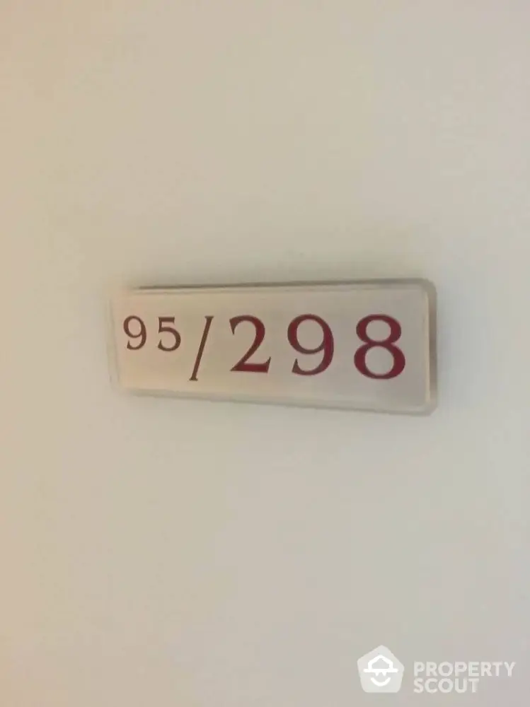 Apartment number sign on a white wall indicating unit 95 out of 298.