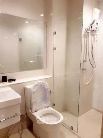 Modern bathroom with glass shower and sleek fixtures in a contemporary apartment.