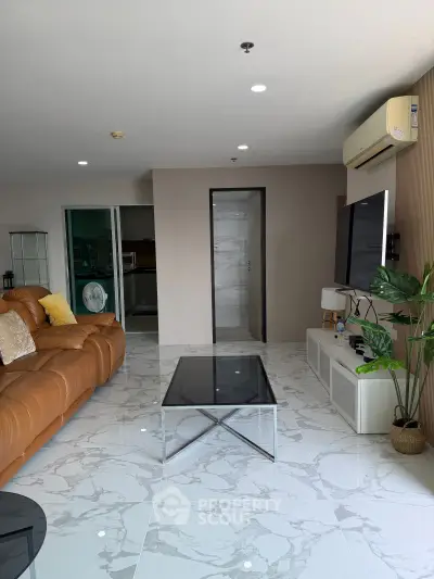 Spacious modern living room with sleek marble flooring and stylish leather sofa.