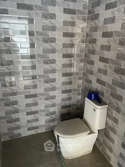 Modern bathroom with sleek tiled walls and contemporary toilet design.