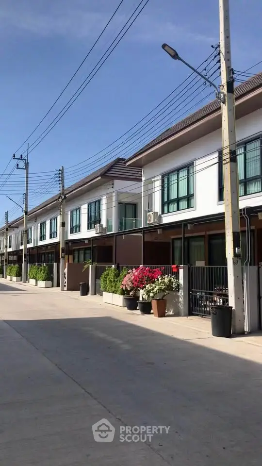 Modern townhouse exterior with clean lines and lush landscaping in a serene neighborhood.