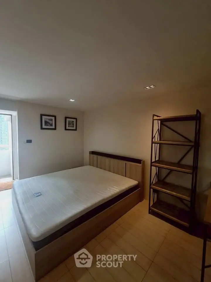 Spacious bedroom with modern wooden bed and shelving unit, perfect for a cozy retreat.
