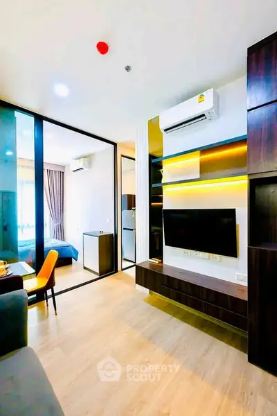 Modern living room with sleek design and open layout, featuring a wall-mounted TV and stylish furniture.